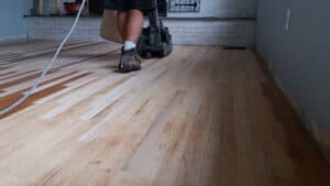 hardwood flooring in a living room being sanded.